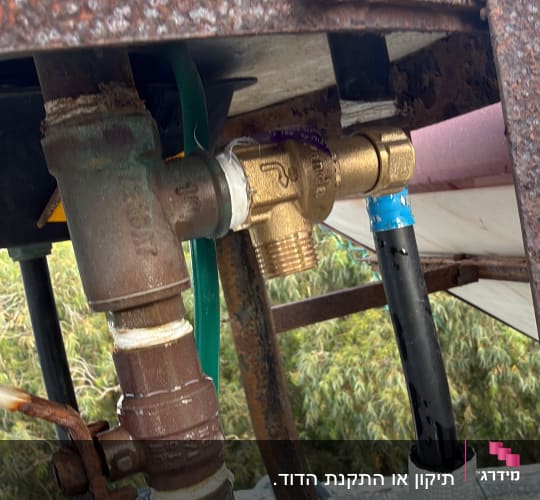 חיבורים וצינורות מתכת חלודים על גג